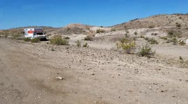 Uhaul driving in the middle of the desert, on a dirt road.