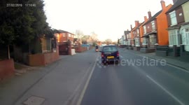 moped and van driving on path around traffic queue