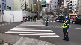Three Workers Direct Pedestrians At Zebra Crossing In Japan