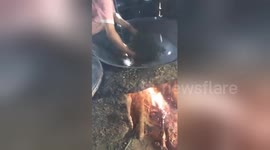 Fireproof! Man uses bare hands to sift tea leaves in a fiery pan