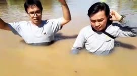 Indonesian residents struggle to walk through submerged road amid devastating flooding