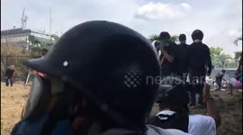 Caracas clashes - close up of protesters throwing rocks as shots are fired back