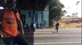 Caracas clashes - protesters under a bridge attack Venezuela police with rocks