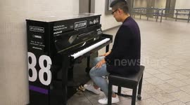 Chinese musician play a piano at King Cross Station