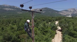Technician of electric company of Greece climbs a transmission pylon