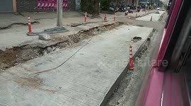 Bus in Bangkok is Steadily Avoiding Falling into the Cracks of the Road in Construction Area