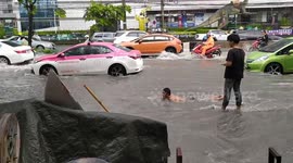 Man goes surfing on flooded road after heavy rain