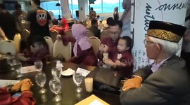 a father gives his child a drink at the dinner table