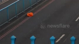 Orange Bag Trys To Hold Onto The Road