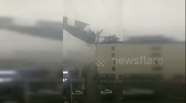 Roof ripped off by strong wind crashes onto parked vehicles below in northern China