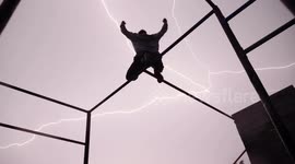 Free runner strikes a pose perfectly as bolts of lightning ignite the sky