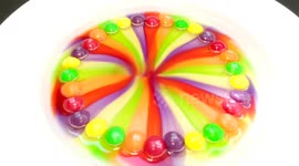 Skittles melt turning clear water into colours of the rainbow