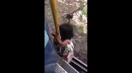Dangerous moment a 4-year-old girl hangs from the footboard of a running train and gets down on the track