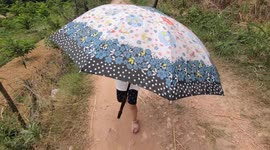 Little girl struggled to hold the big umbrella but still enjoyed it