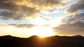 sunset between clouds and mountains.