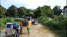 Drivers stranded after swollen river floods bridge in the Philippines