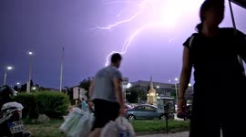 Lightning flashes above casual passersby as storms lash Thessaloniki