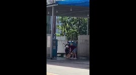 Moped rider stops at petrol station to clean his dog with the forecourt's JET WASHER