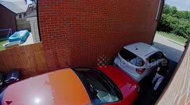 This is the moment a woman driver accidentally rammed her husband's car backwards through their garage door