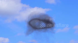 Black smoke ring floating in the sky above Yorkshire.