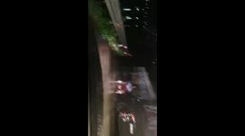 A man in a wheelchair on a rainy road