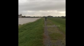 People biking and walking on levee before storm