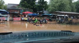 Children play on flooded road after monsoon rains in Thailand