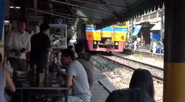Locals eat at tables just inches from passing trains at Thai restaurant