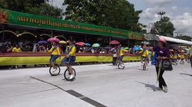 Adorable moment dozens of Thai schoolgirls dance on unicycles at Buddhist festival