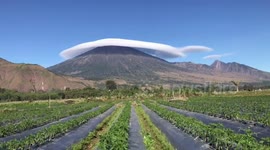 Spectacular moment long flat cloud blankets Indonesian volcano peak 'like a hat'