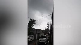 Tornado picks up debris from damaged buildings while tearing through village
