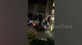 Woman rescued after riding into uncovered drain during flood in the Philippines