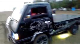 Renovated pick up trucks do doughnuts on Sumatran beach