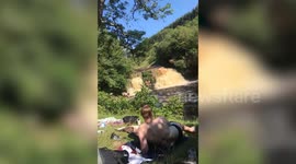 This is the horrifying moment a teenager was pushed from a 30ft waterfall by a sudden gush of water - miraculously escaping with just a broken wrist