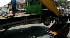 The car tumbled when the excavator climbed into the truck