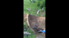 Rider has huge face-plant while jumping dirt ramp on mountain bike