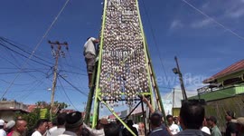 People climb 'tower of cakes' to celebrate Eid in Indonesia