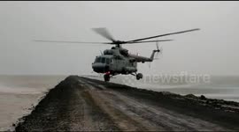 Chopper lands on flood-ravaged highway to rescue 125 people