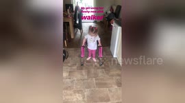 Little girl taking her first steps with walker