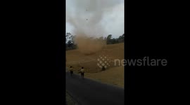 Fearless kids run into massive dust devil in Indonesia