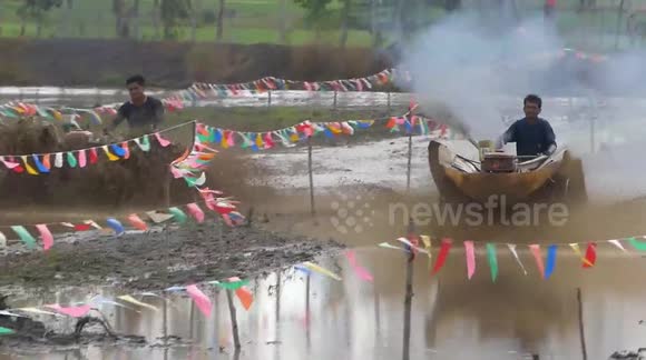 Thai farmers race tractors in paddy fields for rice planting festival ...