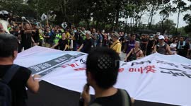 Protesters unfurl a large banner as they begin a protest march despite police earlier banning the march