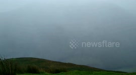 Sideways moving rain through a valley due to wind