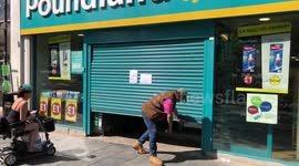 Old man struggles to crawl under jammed roller door at Poundland