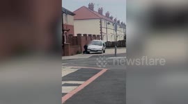 This shocking video shows a group lads flipping a small car on to its side and smashing the driver's window