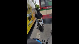 Reckless Thai motorcyclist swerves in between buses