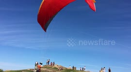 Paragliders take off and land