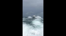 Speedboat races through choppy seas to avoid approaching storm