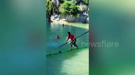 Locals paddle down Chinese river on single sticks of bamboo