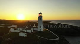 Drone camera captures famous Donegal's Fanad Head lighthouse with setting sun
